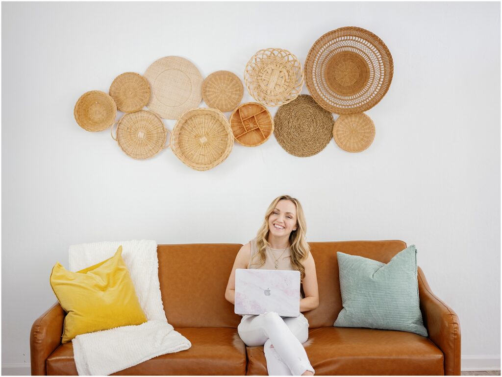 woman working from the couch with basket wall art by Krista Marie Photography, a Bay Area brand photographer