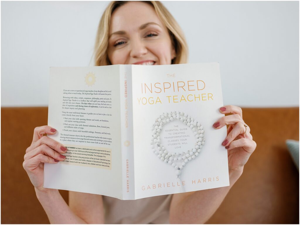 woman reading a yoga book on the couch by Krista Marie Photography, a Bay Area brand photographer